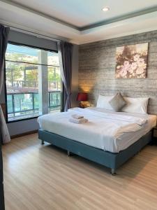a bedroom with a large bed and a large window at Tamnan Resort Pattaya in Ban Nong Chaeng +67 photos
