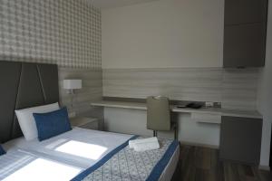 a small bedroom with a bed and a desk at Hotel Fiesa in Piran +57 photos