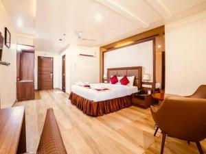 a hotel room with a bed and a desk and chair at Hotel SVM Grand Medipally in Upal +41 photos
