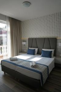 a bedroom with a large bed with blue pillows at Hotel Fiesa in Piran