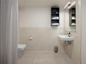 a white bathroom with a sink and a toilet at smartments Frankfurt City-Ost in Frankfurt +39 photos