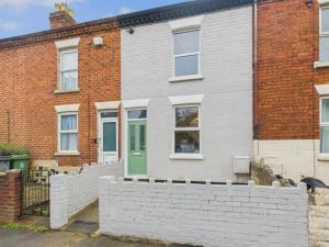 a brick house with a green door at 171 Stroud Road in Gloucestershire