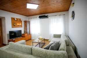 a living room with a couch and a tv at Old Bazaar Balcony Villa in Gjirokastër