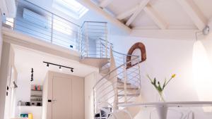 a spiral staircase in a room with a glass table at DOMUS 1435 - Iconic Suites in Centro in Mantova
