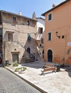 an empty street with a bench in front of buildings at La Corte di GreSi in Tivoli +4 photos