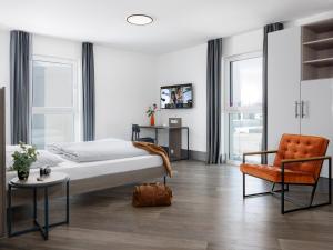 a bedroom with a bed and a chair at smartments Frankfurt City-Ost in Frankfurt