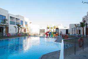a large swimming pool with a playground in a city at Hafawah Resort in Medina