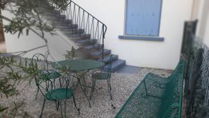 a patio with tables and chairs next to a staircase at T2Leucate La Franqui Calme Mer Clim Parking P in Leucate