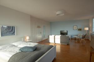 a white bedroom with a bed and a living room at B&B Zoo Caffè & Ristorante in Zurich