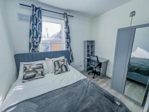 a bedroom with a bed with a mirror and a desk at Eugino Properties in Grays Thurrock +6 photos
