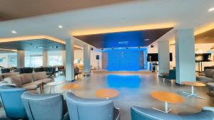 a waiting room with blue chairs and tables at BLUESEA Corralejo Village in Corralejo