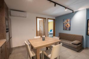 a living room with a wooden table and a couch at Stillel Retreat Suites in St. Paul's Bay +41 photos