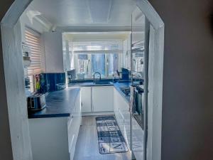 a kitchen with white cabinets and a sink at Eugino Properties in Grays Thurrock