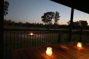 a wooden table with candles on top of a deck at Rivergums Cottage in Dubbo