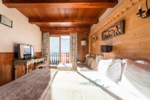 a bedroom with a bed and a couch and a television at Hôtel les Campanules by Les Etincelles in Tignes