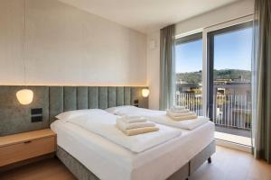 two beds in a bedroom with a large window at Villa Olivida in Garda +72 photos