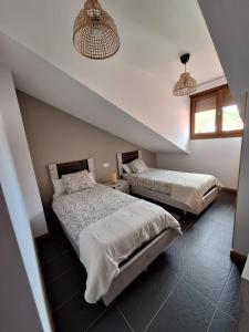 a bedroom with two beds and two pendant lights at Aldea Bricia 20 BC in Posada de Llanes