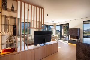 a living room with a flat screen tv on a cabinet at Villa Olivida in Garda