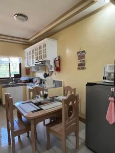 a kitchen with a table and chairs and a refrigerator at Nielo's Apartment Door 5 in Dapitan
