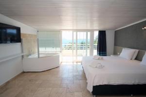a bedroom with a bed and a bath tub and a television at Nur Hotel in Kaş +60 photos
