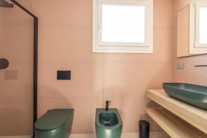 a bathroom with a green toilet and a sink at Dimora Suite Platino in Gallipoli +21 photos
