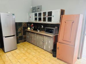 a kitchen with white cabinets and a refrigerator at KleinHenties in Hentiesbaai