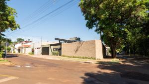 an empty street with a building and a tree at Jahu Center House in Jaú