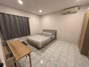 a small bedroom with a bed and a table at Il Piccolo Paradiso - Hôtel in Koh Samui