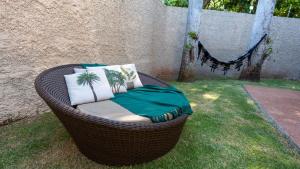 a wicker rattan chair sitting on the grass at Jahu Center House in Jaú