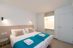 a bedroom with a large bed with two towels on it at Ereza Suites in Arrecife