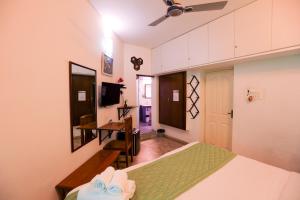a bedroom with a bed and a desk in it at Le Clarisse Guest House in Pondicherry
