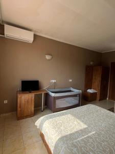 a bedroom with a bed and a desk and a computer at Kompleks Koral Konak in Prezhda