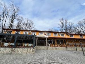 a building with tables and chairs in front of it at Kompleks Koral Konak in Prezhda