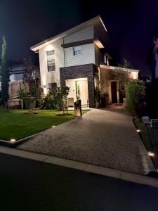 a house with a driveway in front of it at night at Executive Studio - Private Parking in Holmview