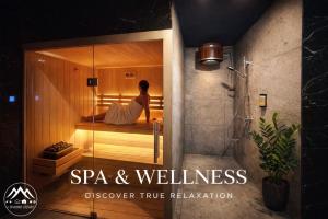 a woman is sitting in a sauna in a bathroom at Domek A - domki w górach z prywatnym SPA - 4 seasons lodges Ustroń in Ustroń