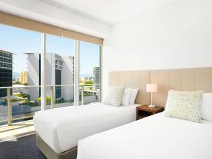 two beds in a hotel room with a large window at Mantra Trilogy in Cairns +111 photos