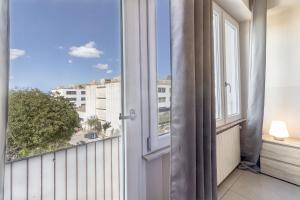 an open door to a balcony with a view of a city at B&B Viale San Pietro in Sassari