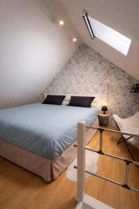 a bedroom with a large bed in a attic at Le petit nid de St-Germain in Saint-Germain