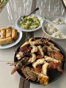 a table with a plate of lobster and other dishes of food at Cucu Suzanne in Lasikin +75 photos