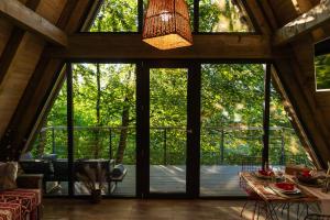 an open living room with large windows and a table at Hai La Munte Bran in Bran