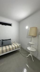 a white room with a bed and a lamp at Como en casa in Concordia
