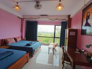 a bedroom with two beds and a desk and a window at HangNga homestay - hotel in Phủ Từ Sơn +81 photos