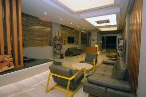 a living room with couches and a table and chairs at Nur Hotel in Kaş