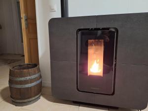 a fire oven with a barrel next to it at Escapade au Lac in Corancy