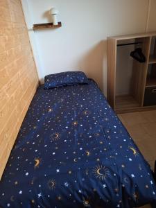 a bed with a blue comforter with gold stars at Escapade au Lac in Corancy