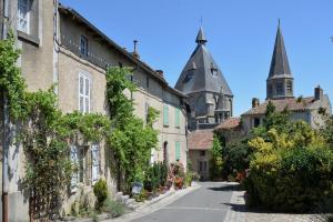 an alley in an old town with a castle at Le Dorat Bright & Quiet in Le Dorat