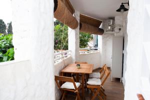 a small balcony with a wooden table and chairs at Casa Mari Pepa beach & pool in Benajarafe