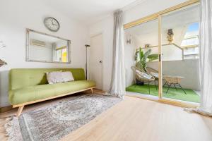 a living room with a green couch and a window at Pet Friendly + Pool + Park, Beach 2 Minutes Away (Atalaya) in Salou +32 photos