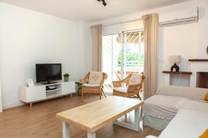 a living room with a couch and a tv at Casa Mari Pepa beach & pool in Benajarafe