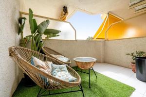 a balcony with two wicker chairs and a green rug at Pet Friendly + Pool + Park, Beach 2 Minutes Away (Atalaya) in Salou